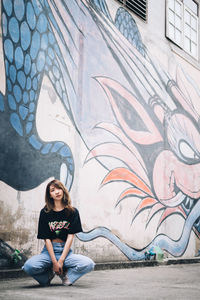 Full length of woman sitting on wall