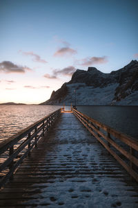 Pier over sea against sky during sunset