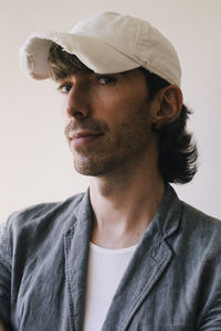 Portrait of male architect wearing cap and blazer against white wall