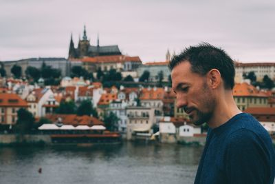 Portrait of man in city against river