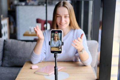 Young woman filming through smart phone