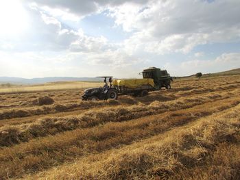 Agricultural machinery on field against sky