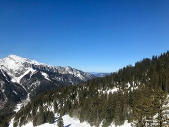 Scenic view of snowcapped mountains against clear blue sky