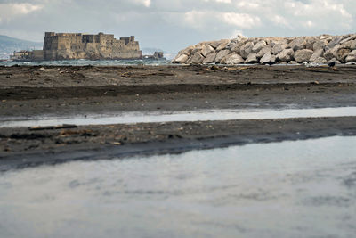 Surface level of rocks on beach against sky