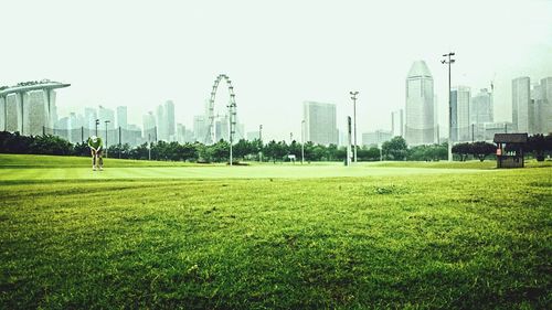 Scenic view of park in city against sky