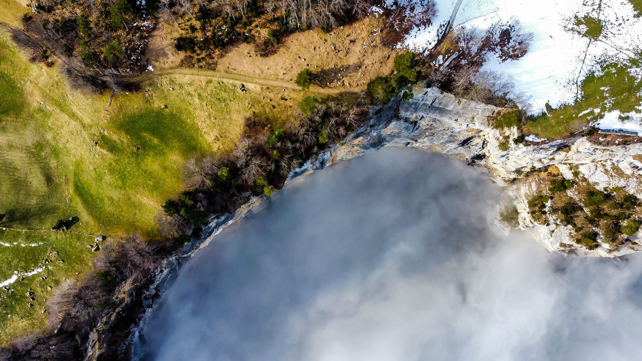 HIGH ANGLE VIEW OF WATERFALL AGAINST SKY