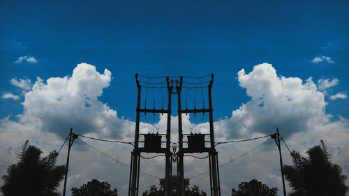 Low angle view of silhouette rollercoaster against sky