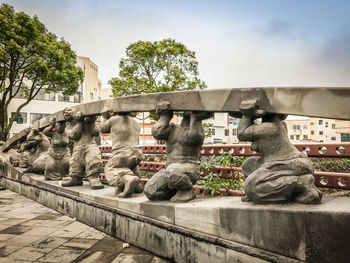 Statue by trees against sky