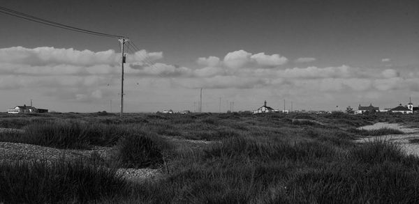 View of grassy field against cloudy sky