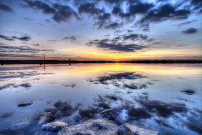 Scenic view of sea against dramatic sky during sunset