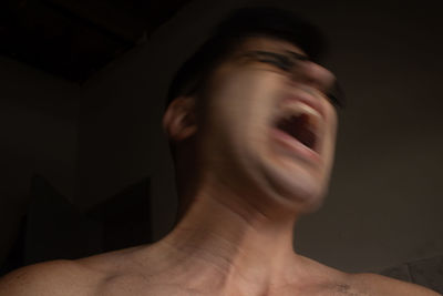 Portrait of shirtless man against black background