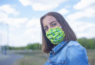 Portrait of young woman standing against sky