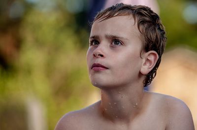 Close-up of wet thoughtful boy outdoors