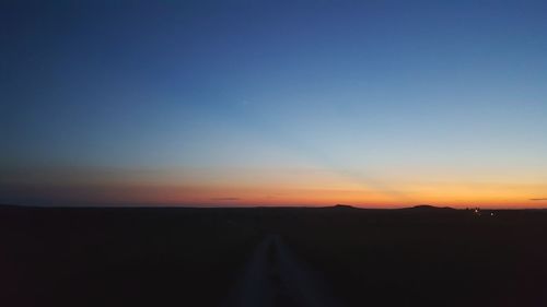 Scenic view of silhouette landscape against clear sky during sunset
