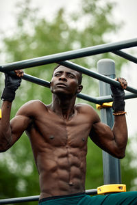 Portrait of shirtless young man exercising outdoors