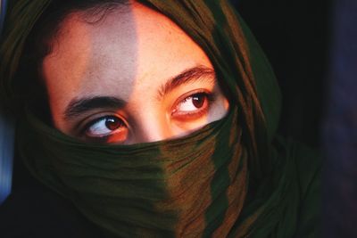 Close-up portrait of young woman covering face