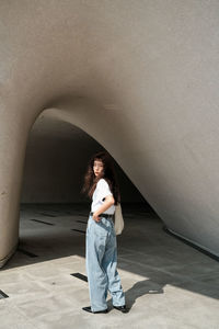 Rear view of young woman standing in tunnel