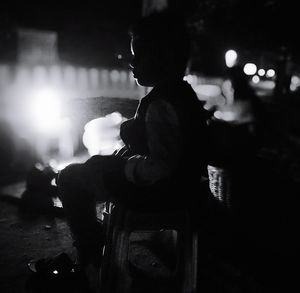 Rear view of silhouette man standing at night