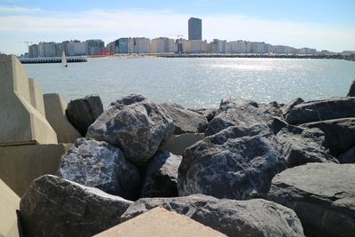 Scenic view of sea by city against sky