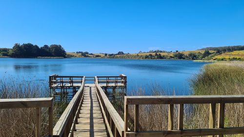 Scenic view of lake against clear blue sky