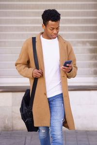 Man using mobile phone walking outdoors