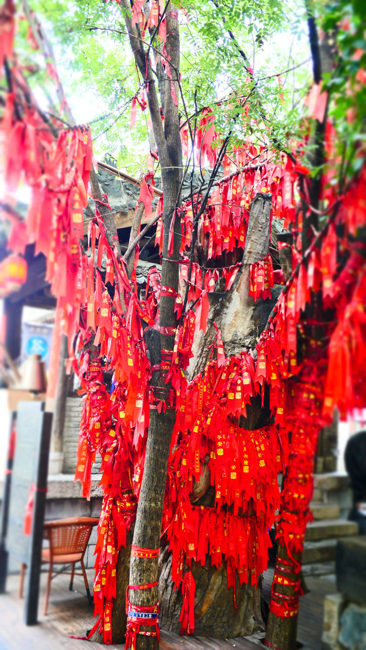 RED BELL TOWER AMIDST TREES AND BUILDINGS