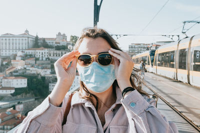 Portrait of woman wearing sunglasses while standing in city