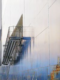 Reflection of building on glass against sky