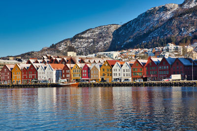 Buildings by town against clear blue sky