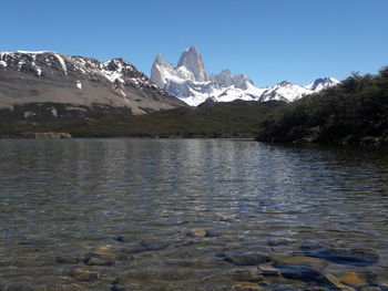 Scenic view of lake and snowcapped mountains against sky