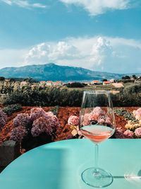 Glass of wine on table against sky