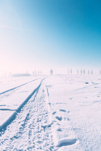 Snow covered field against clear sky