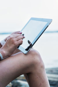 Close-up of girl using digital tablet at water