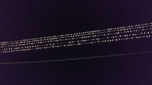 Low angle view of illuminated lights against clear sky at night