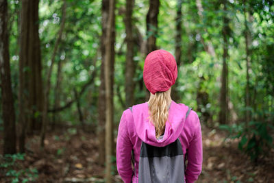 Woman standing against trees in forest