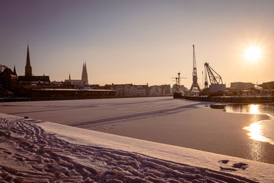 View of buildings at waterfront during sunset