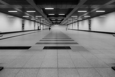 Perspective of a empty illuminated walkway in the subway black and white