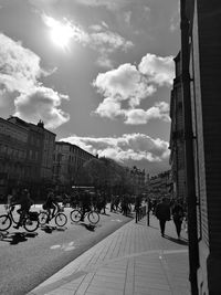 People on street in city against sky