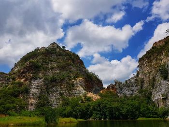 Scenic view of rocks by lake against sky