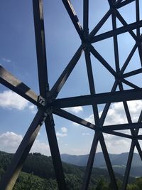 Low angle view of metallic structure on field against sky