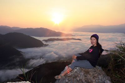 Woman standing on mountain at sunset