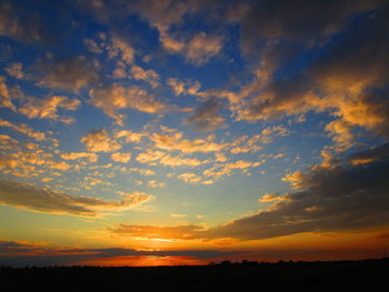 Scenic view of dramatic sky over silhouette landscape