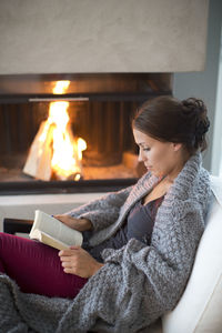 Young woman sitting on book