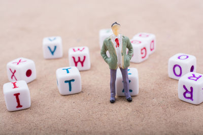 Close-up of male figurines with letter dices on table