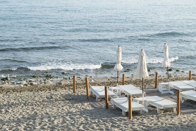 High angle view of empty deck chairs and parasols at beach