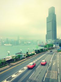 Traffic on road in city against sky