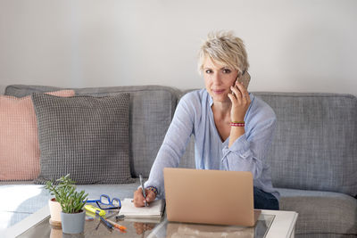 Woman using laptop on couch at home