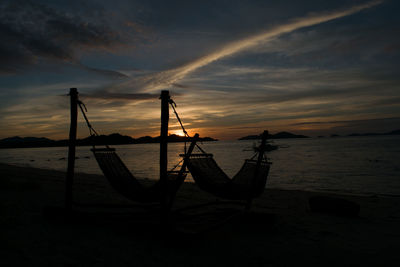 Silhouette boat on beach against sky during sunset