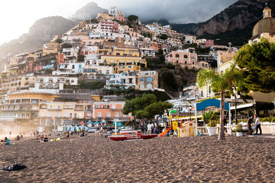 Cars on beach by buildings in city