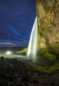 Scenic view of waterfall against sky